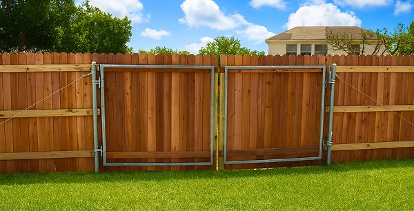 Vertical wood fence with metal supportive frame on gate.