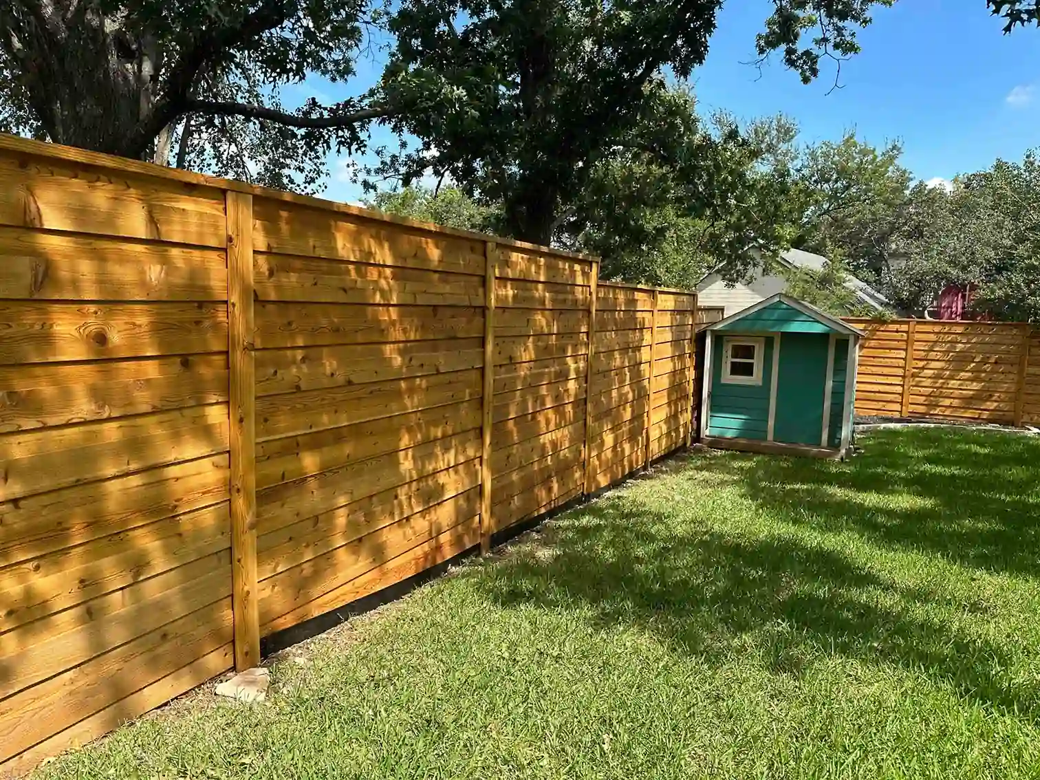 Horizontal cedar board on board fence with cap and trim in Austin backyard