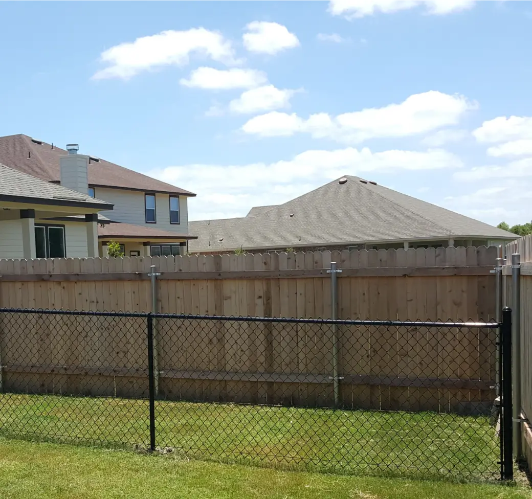 Chain link fence with black vinyl coating enclosing a Texas backyard